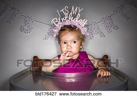 Stock Photo - Caucasian baby girl wearing birthday crown. Fotosearch