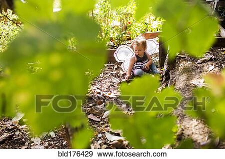Stock Photo - Caucasian baby girl wearing fairy wings in garden. Fotosearch