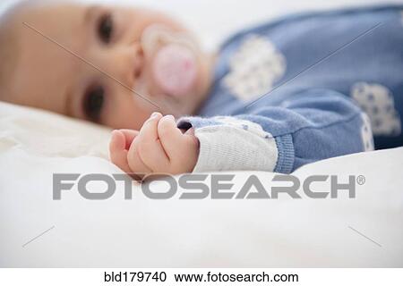 Stock Image - Caucasian baby girl with pacifier. Fotosearch