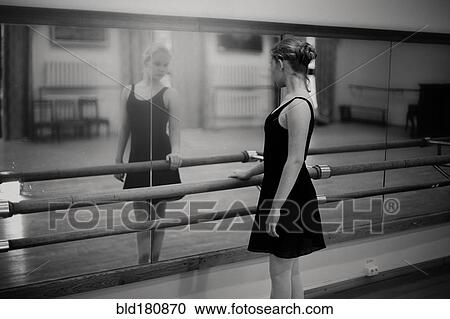 Stock Image - Caucasian ballerina standing at barre. Fotosearch