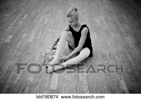 Picture - Caucasian ballerina tying pointe shoes. Fotosearch