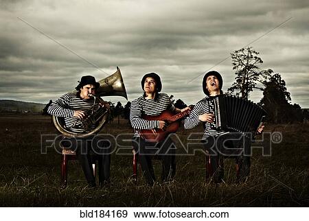 Stock Photo - Caucasian band playing instruments in field. Fotosearch