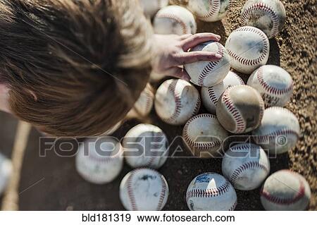 Stock Photo - Caucasian boy choosing baseball on field. Fotosearch