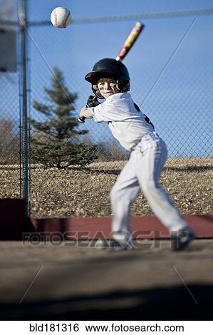 Caucasian boy hitting baseball on field View Large Photo Image Stock Photograph - Caucasian boy hitting baseball on field. Fotosearch