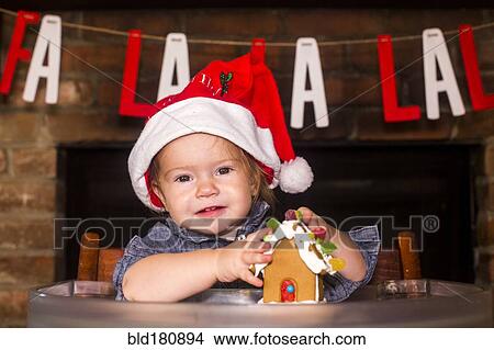 Picture - Caucasian boy holding gingerbread house. Fotosearch