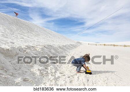 Stock Photograph - Caucasian boy playing with toy truck in desert. Fotosearch