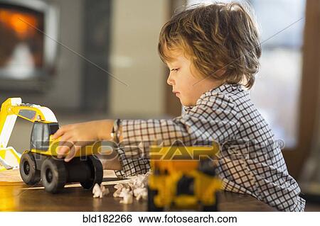 Stock Photograph - Caucasian boy playing with trucks. Fotosearch