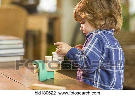 Stock Image - Caucasian boy playing with wooden blocks. Fotosearch