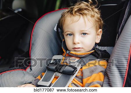 Stock Photo - Caucasian boy sitting in car seat. Fotosearch
