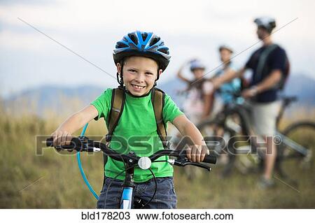 Stock Image - Caucasian boy smiling on mountain bike. Fotosearch