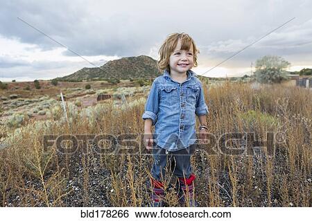 Caucasian boy smiling on rural hillside View Large Photo Image Stock Photograph - Caucasian boy smiling on rural hillside. Fotosearch