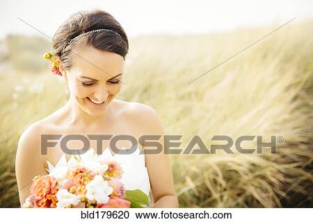 Caucasian bride standing in grass View Large Photo Image Stock Image - Caucasian bride standing in grass. Fotosearch
