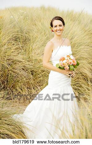 Stock Photo - Caucasian bride standing on beach. Fotosearch