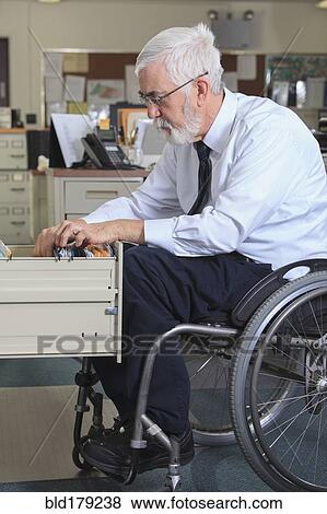 Caucasian businessman filing papers in office View Large Photo Image Stock Photo - Caucasian businessman filing papers in office. Fotosearch