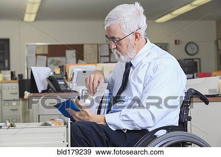 Caucasian businessman filing papers in office View Large Photo Image Stock Photo - Caucasian businessman filing papers in office. Fotosearch