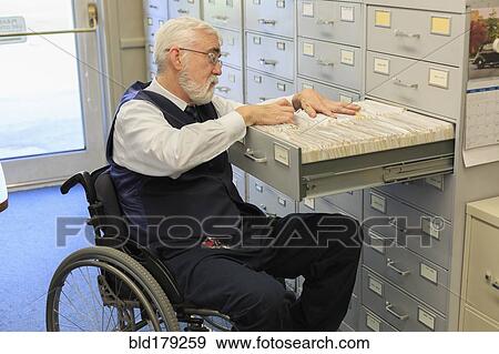 Stock Photo - Caucasian businessman filing papers in office. Fotosearch