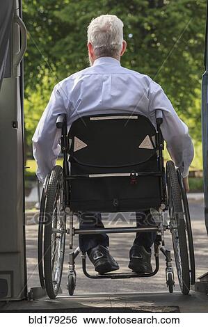 Stock Photograph - Caucasian businessman in wheelchair exiting van. Fotosearch