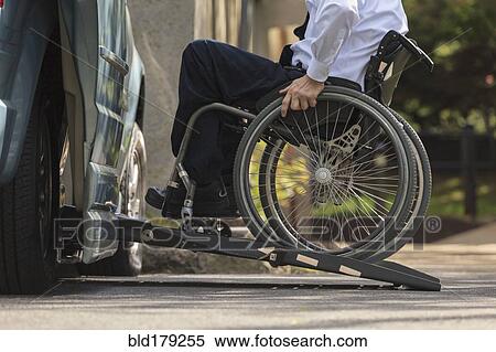 Stock Photography - Caucasian businessman in wheelchair entering van. Fotosearch
