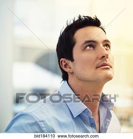 Stock Image - Caucasian businessman looking up. Fotosearch