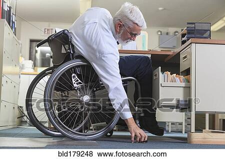 Stock Photo - Caucasian businessman picking up object on floor. Fotosearch