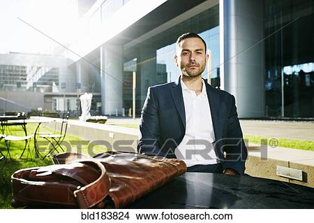 Picture - Caucasian businessman sitting outdoors. Fotosearch