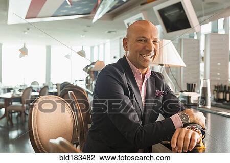 Caucasian businessman smiling in bar View Large Photo Image Stock Image - Caucasian businessman smiling in bar. Fotosearch