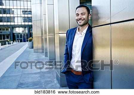 Caucasian businessman smiling outside office building View Large Photo Image Stock Photograph - Caucasian businessman smiling outside office building. Fotosearch