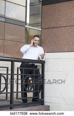 Caucasian businessman talking on cell phone outdoors View Large Photo Image Stock Photo - Caucasian businessman talking on cell phone outdoors. Fotosearch
