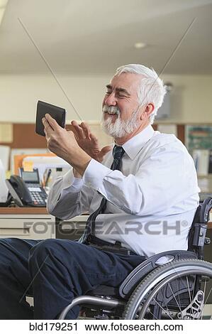 Stock Image - Caucasian businessman using digital tablet in office. Fotosearch