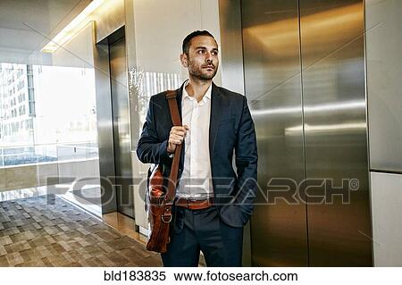 Stock Photography - Caucasian businessman waiting for office elevator. Fotosearch