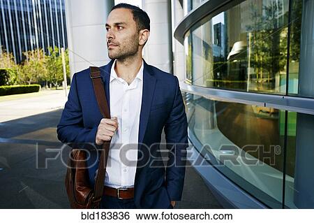 Stock Photograph - Caucasian businessman walking outside office building. Fotosearch