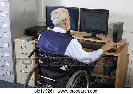 Stock Image - Caucasian businessman working at desk. Fotosearch