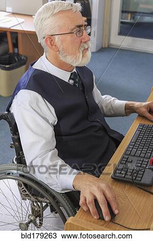 Stock Image - Caucasian businessman working at desk. Fotosearch