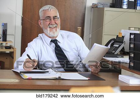 Stock Image - Caucasian businessman working in office. Fotosearch
