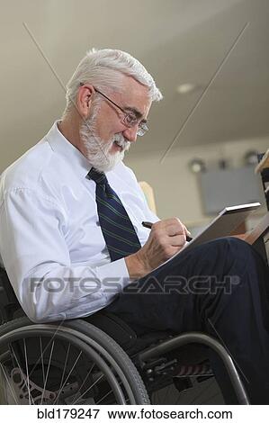 Stock Photo - Caucasian businessman writing on notepad in office. Fotosearch