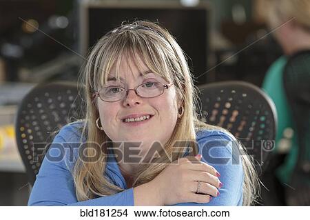 Caucasian businesswoman with Down Syndrome smiling in office View Large Photo Image Picture - Caucasian businesswoman with Down Syndrome smiling in office. Fotosearch