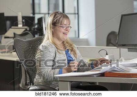 Stock Photograph - Caucasian businesswoman with Down Syndrome working in office. Fotosearch