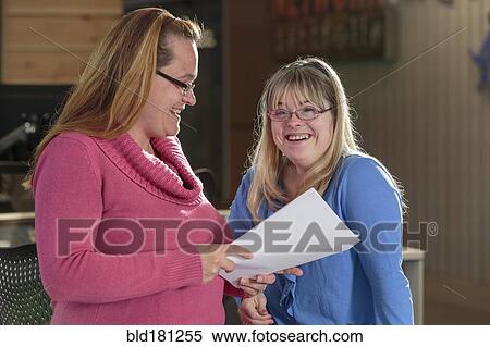 Stock Photography - Caucasian businesswomen talking in office. Fotosearch