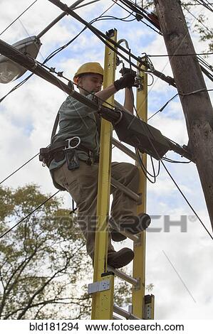 Picture - Caucasian cable installer working on ladder. Fotosearch