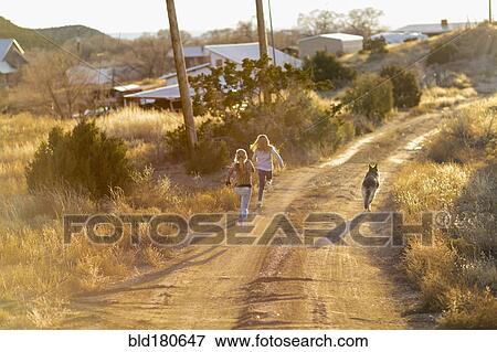 Caucasian children running on dirt road with dog View Large Photo Image Stock Photo - Caucasian children running on dirt road with dog. Fotosearch