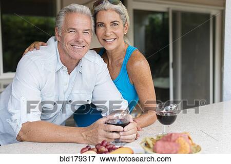 Stock Photo - Caucasian couple drinking wine at table. Fotosearch
