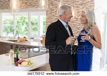 Caucasian couple drinking wine in kitchen View Large Photo Image Stock Image - Caucasian couple drinking wine in kitchen. Fotosearch