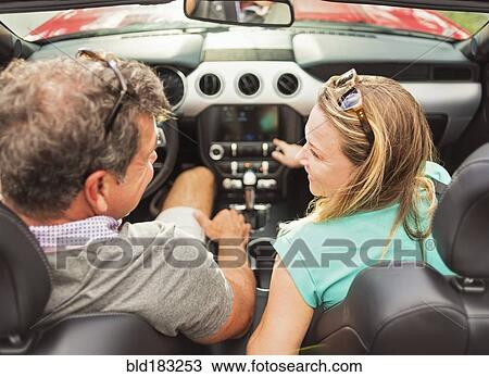 Stock Image - Caucasian couple driving convertible. Fotosearch