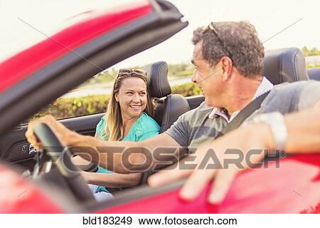 Stock Photo - Caucasian couple driving convertible. Fotosearch