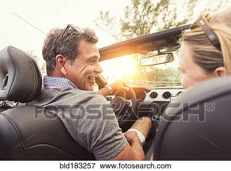 Stock Photo - Caucasian couple driving convertible. Fotosearch