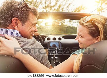Stock Photograph - Caucasian couple driving convertible. Fotosearch