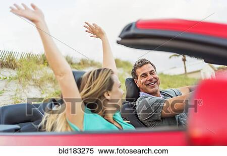 Stock Photography - Caucasian couple driving in convertible. Fotosearch