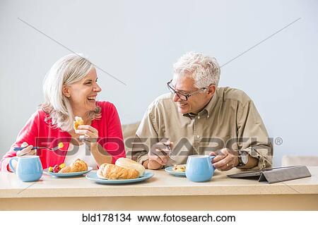 Picture - Caucasian couple eating at table. Fotosearch