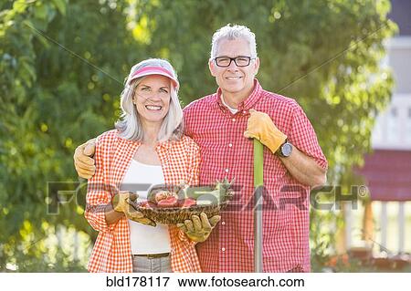 Caucasian couple gardening in backyard View Large Photo Image Stock Photo - Caucasian couple gardening in backyard. Fotosearch