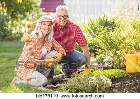Stock Photo - Caucasian couple gardening in backyard. Fotosearch